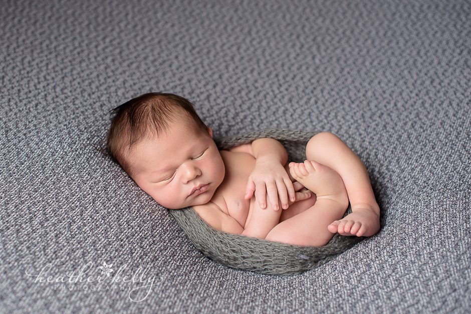 newborn boy on gray and wrapped
