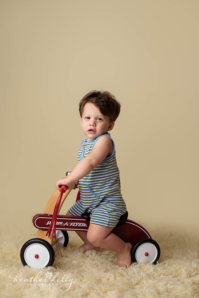 studio photography with toddler boy on tricycle