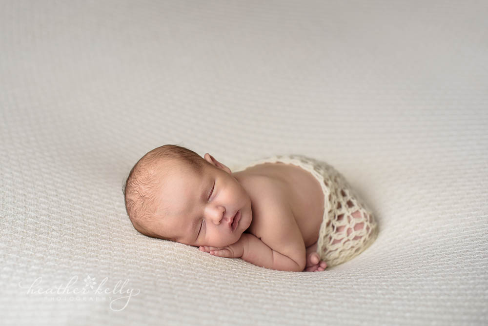 newborn photography taco pose on cream blanket