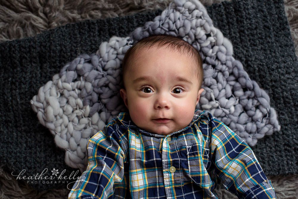 6 month old laying on gray rug photography session