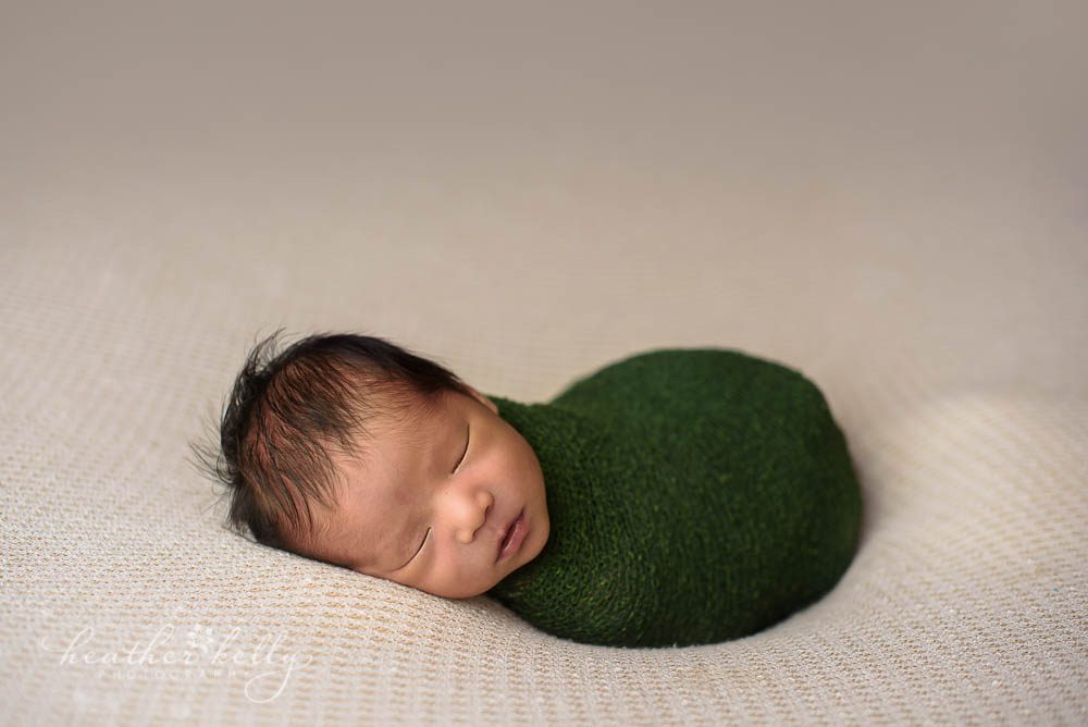 norwalk ct newborn boy wrapped as snug as a bug in green photo