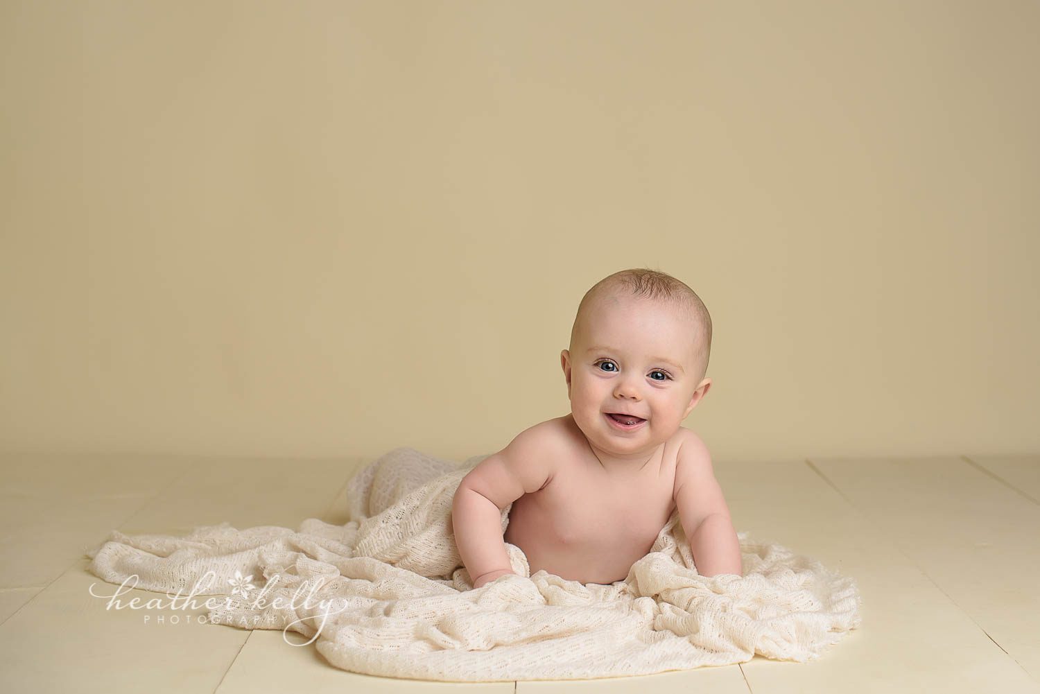 smiling 7  month baby on cream wood floor with blanket photo. newtown baby boy by ct photographer heather kelly photography