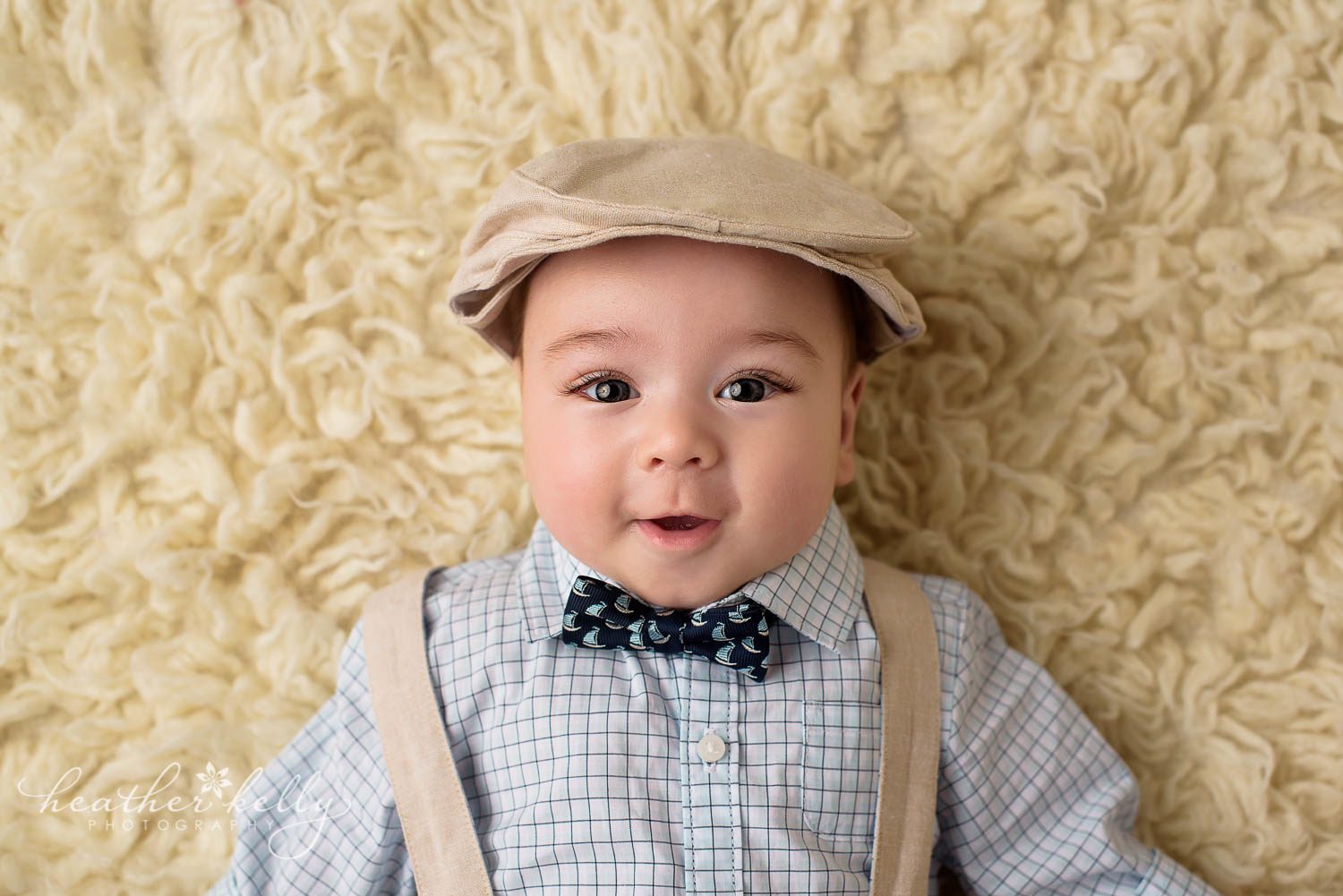 close up photo of baby boy 4 months wearing bow tie, suspenders, and cap.sandy hook ct baby photography