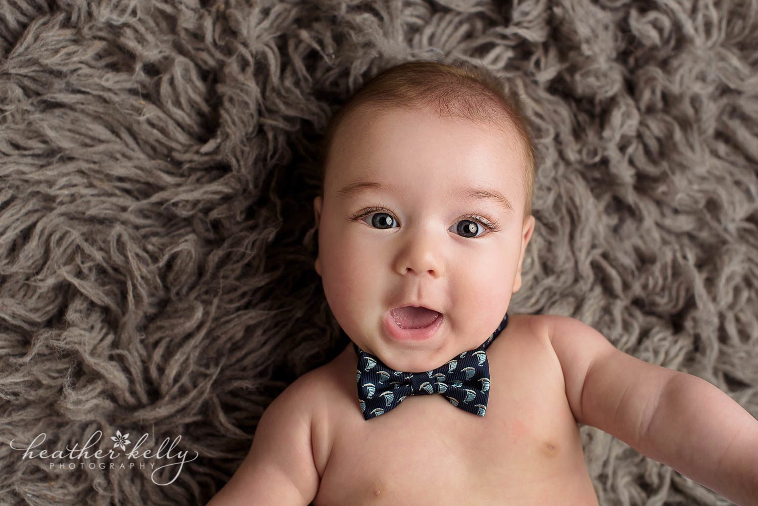 happy 4 month old baby boy with bow tie on gray rug photo. sandy hook ct baby photography