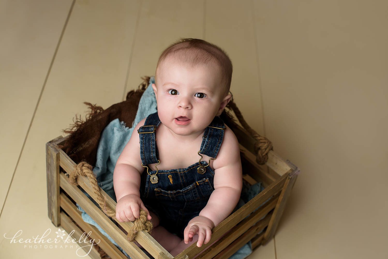 6 month boy sitting in crate. danbury baby boy