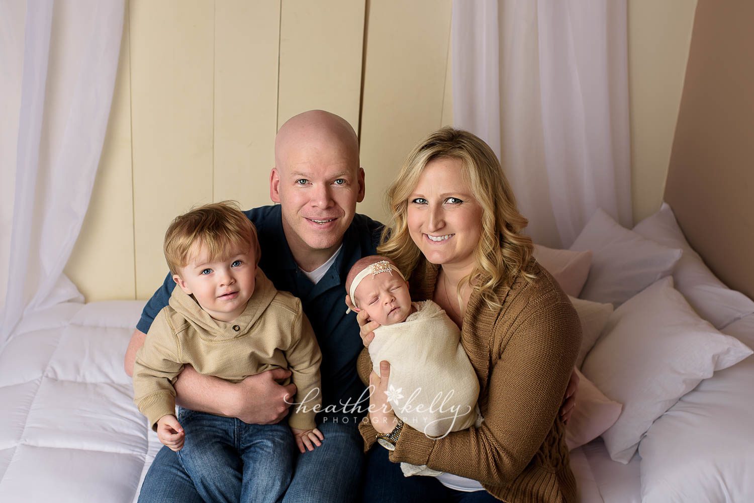 new family of four on bed photo. trumbull ct newborn photography
