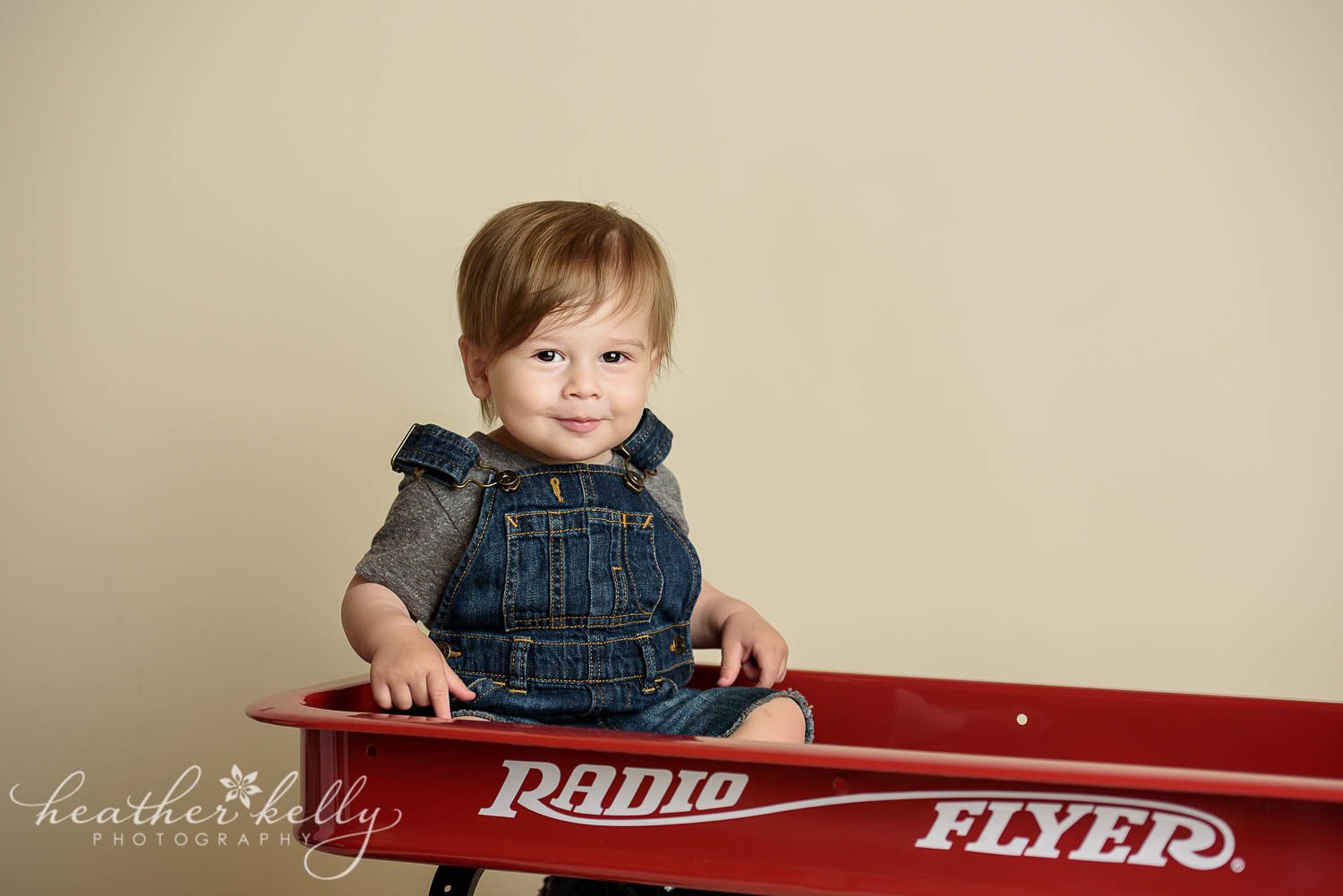 boy in radio flyer wagon and overalls. little red wagon cake smash