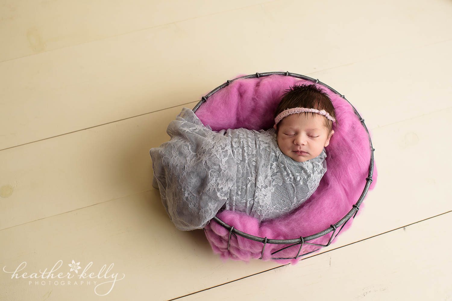 newborn girl wrapped in wire basket. gray and hot pink. newborn wrapping poses