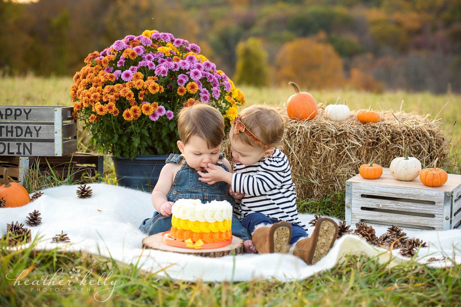 sister feeding one year old brother cake during outdoor cake smash session in Newtown CT. 