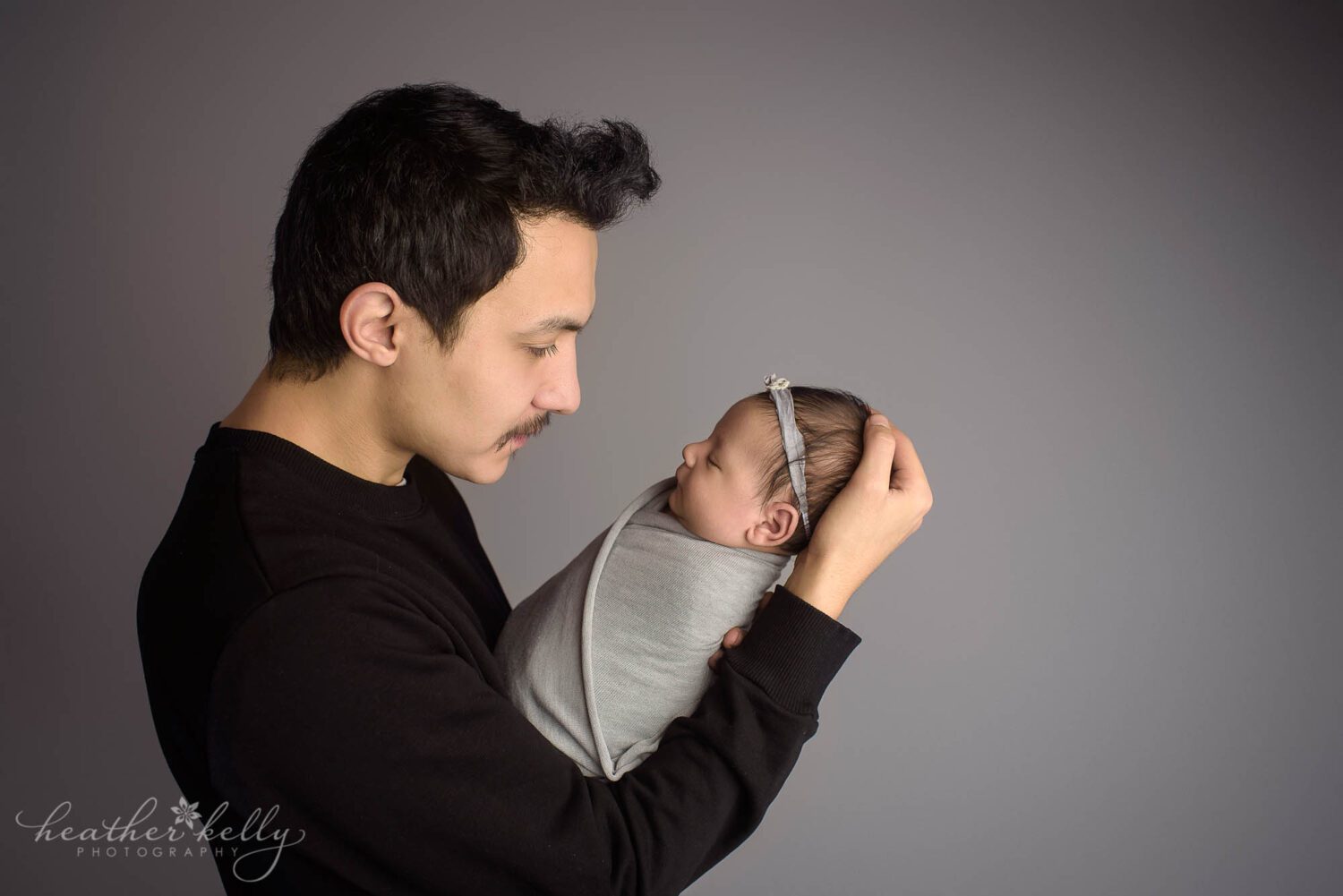 parent and newborn photo of a dad holding and looking at his newborn girl