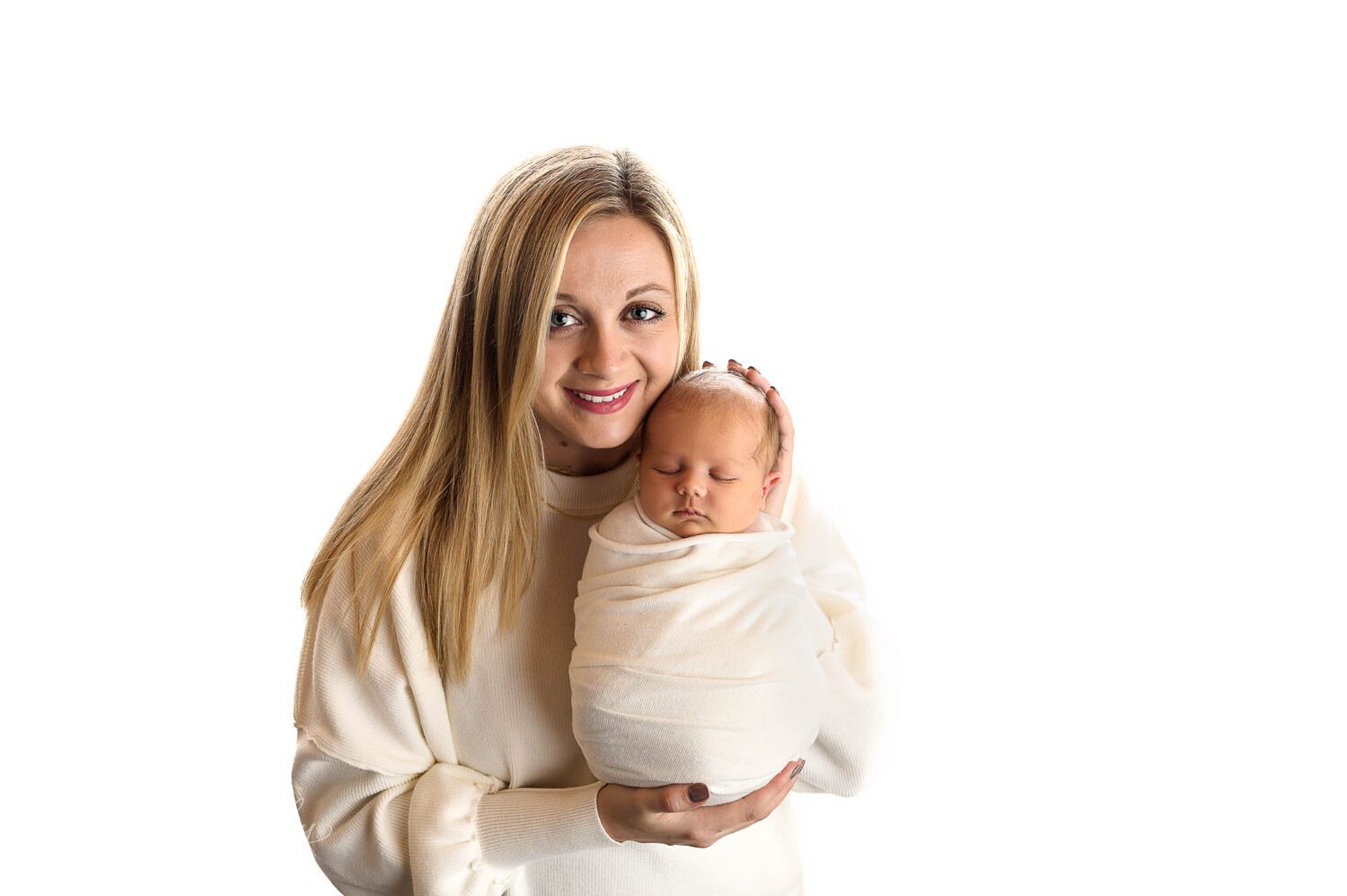 a new mom poses with her newborn boy 