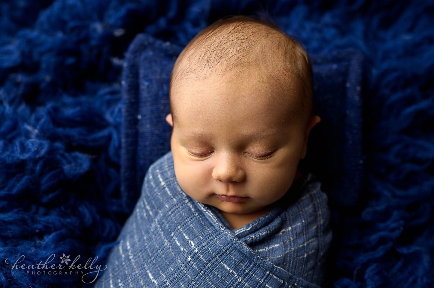 a newborn boy is swaddled in blue for his newborn photography session in bridgeport ct. 