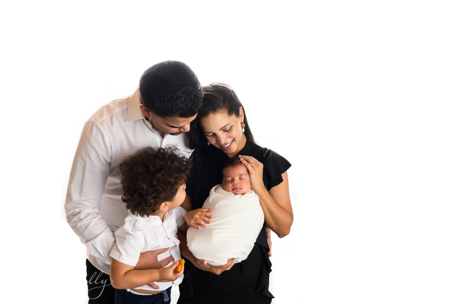 A family of four poses for a family photo taken during their newborn photography session. 
