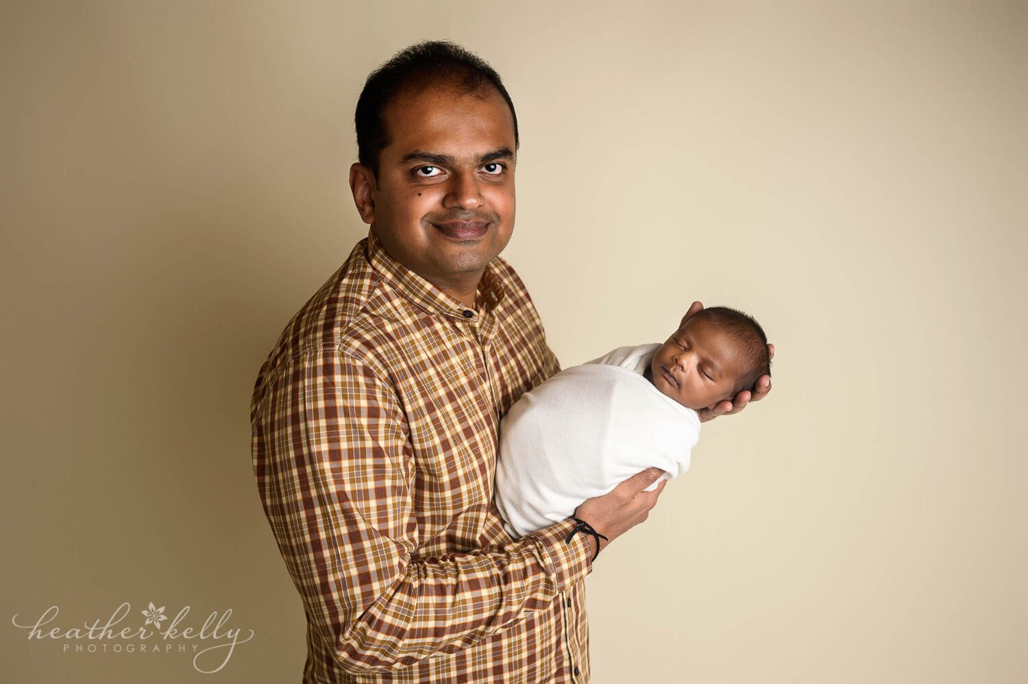 a dad holding his newborn boy 