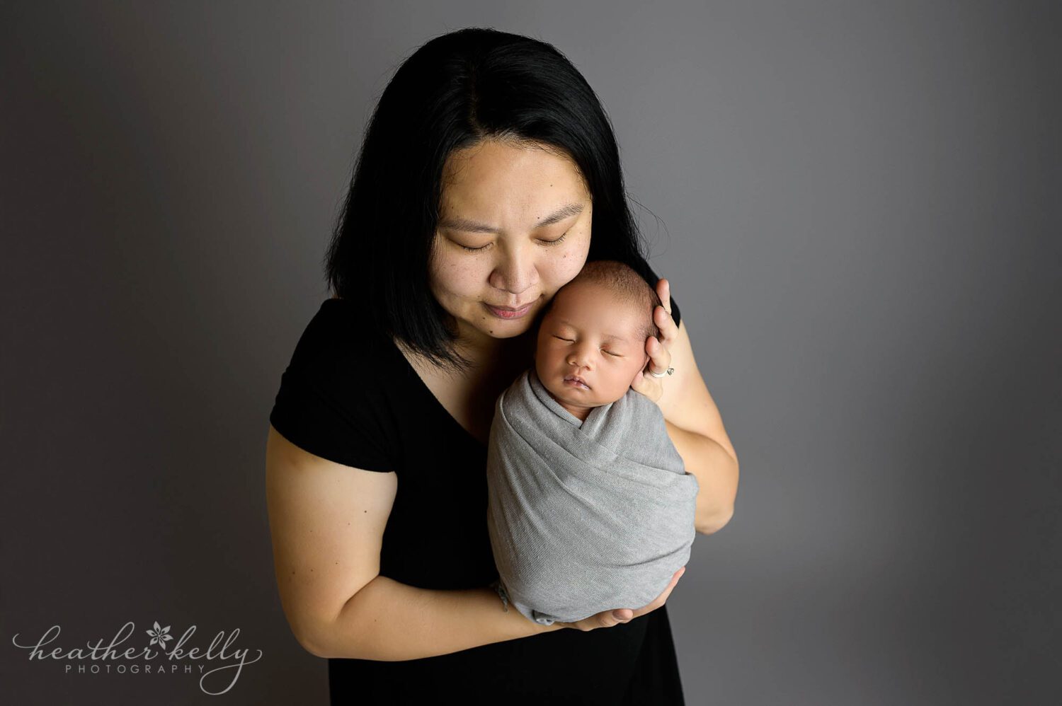A mom holds her newborn boy during a CT photography session 