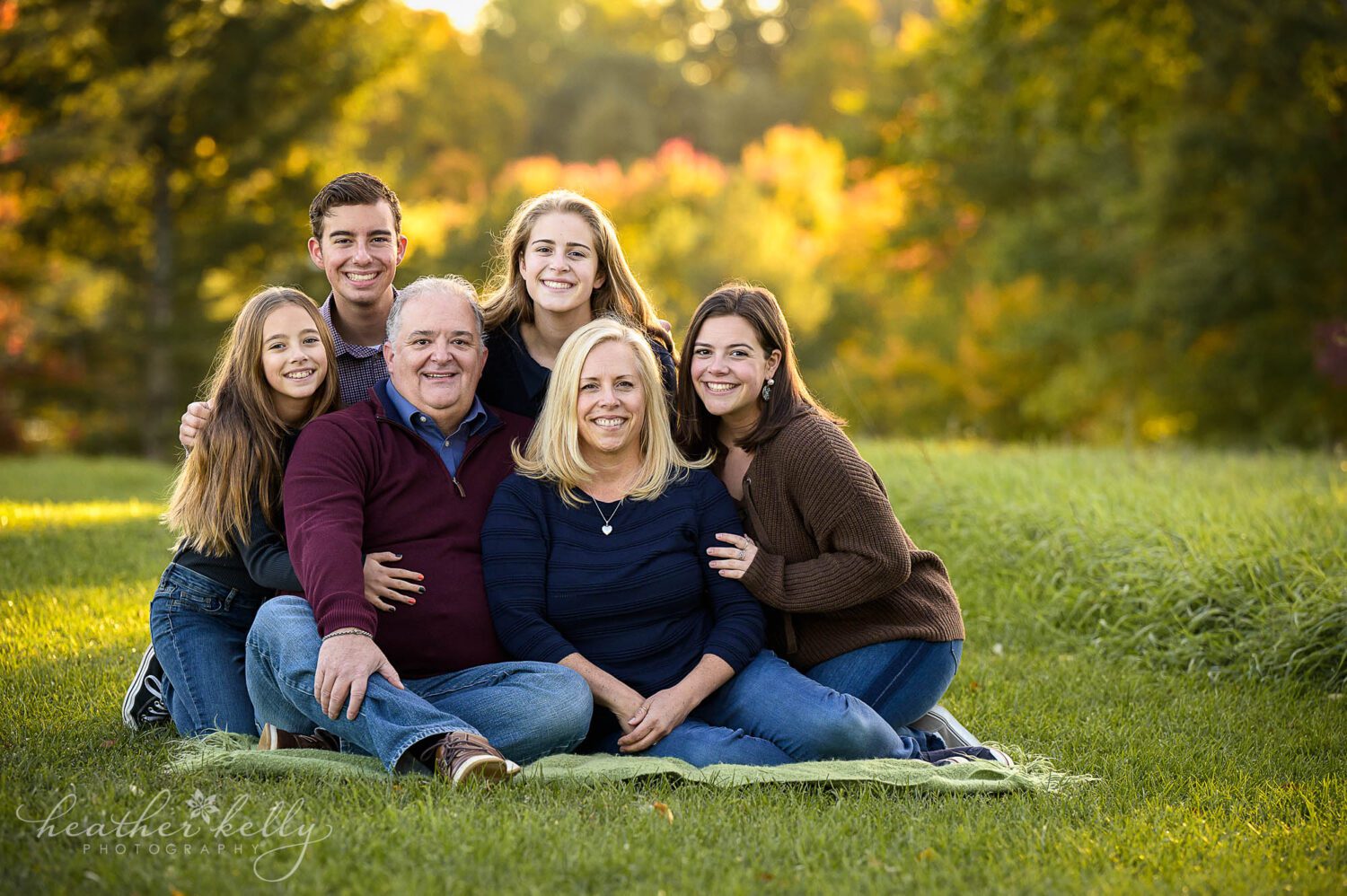 sandy hook ct family photography session. A portrait of a family of 6 sitting in the grass and smiling. 