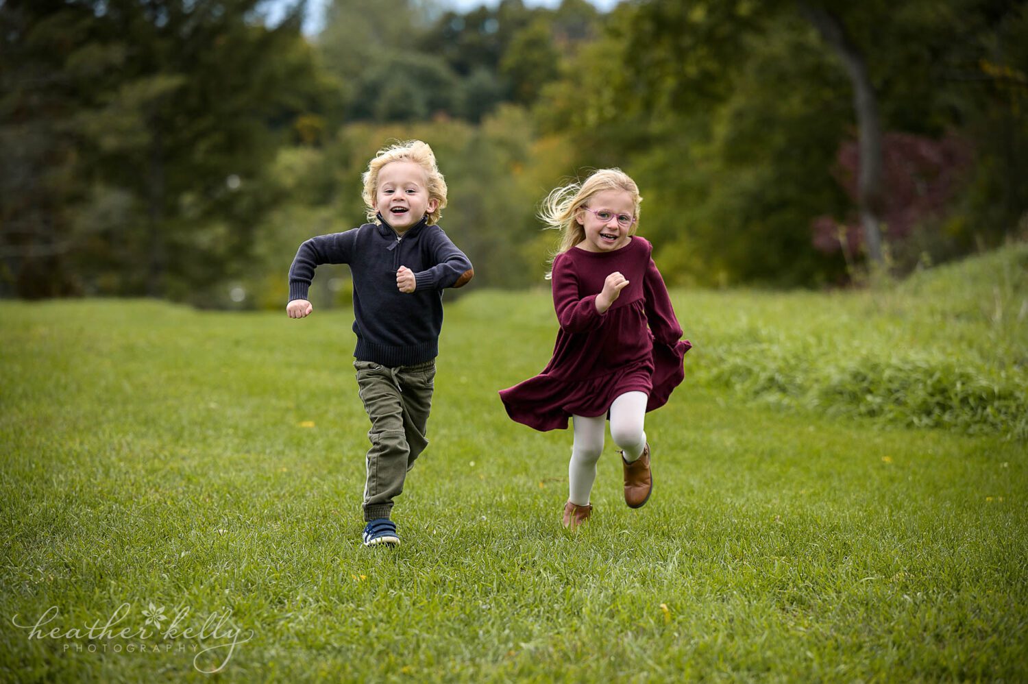 a brother and sister run together during their photography session in bethel ct. 