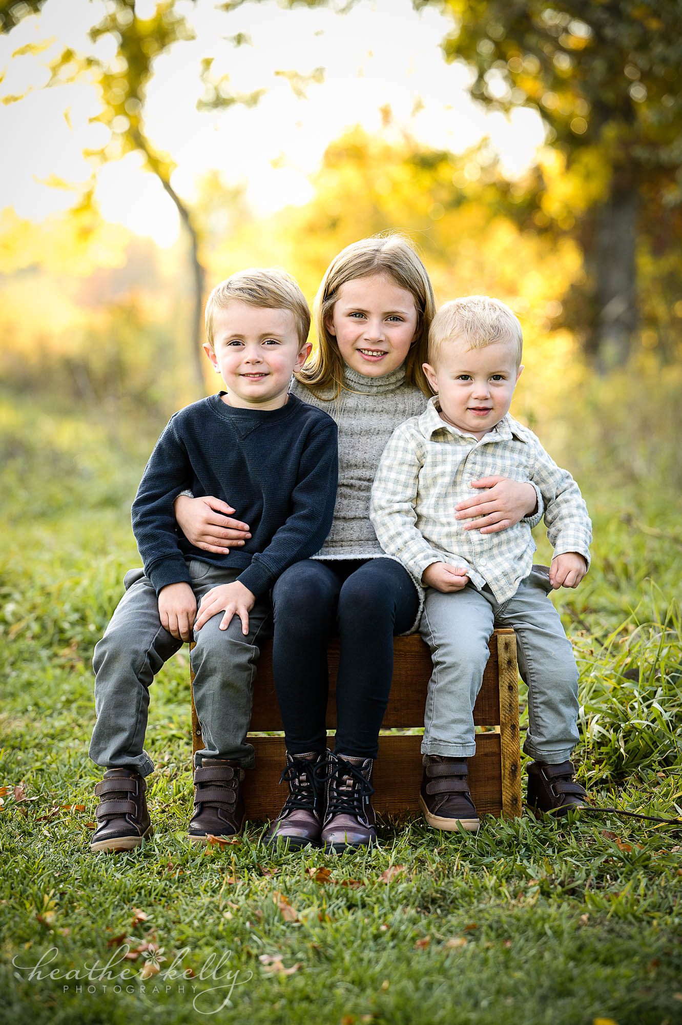 3 siblings sit on a crate during their fall mini session in connecticut. 